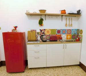 una cocina con nevera roja junto a un fregadero en Casa di Peppe, en Catania