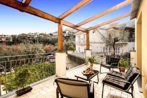 Un patio con sillas y una mesa en un balcón. en CHEZ MARIE' - modern apartment in countryside, en Sorrento