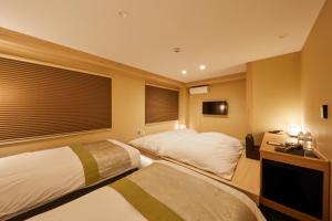 a bedroom with two beds and a window with blinds at Rinn Shirakawa South in Kyoto