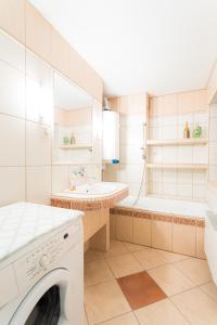 a white bathroom with a washing machine and a tub at Między Zdrojami in Rymanów