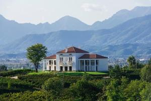 a house on a hill with mountains in the background at Villa Maria Vittoria in Nervesa della Battaglia