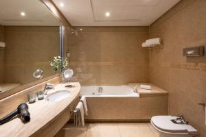 a bathroom with a tub and a sink and a toilet at Hotel San Sebastián Orly, Affiliated by Meliá in Donostia-San Sebastián +37 photos