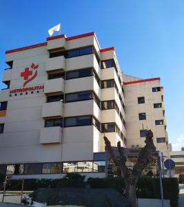 a white building with a red cross on it at Leo's home in Athens