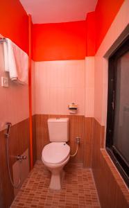 a bathroom with a white toilet and red walls at Blue Mountain Home Stay in Kathmandu