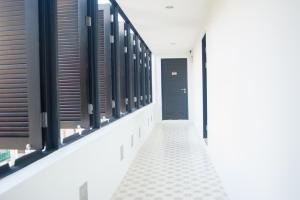 a hallway with black windows and a black door at Baan Ploy In in Chiang Mai