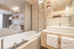 La salle de bains est pourvue d'une baignoire, d'un lavabo et d'un miroir. dans l'établissement Hotel Olympia, à Obergurgl