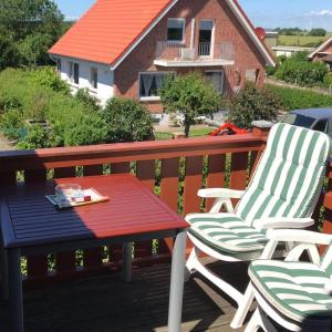 a pair of chairs and a table on a deck at Ferienwohnung Ostseeperle in Lemkenhafen auf Fehmarn