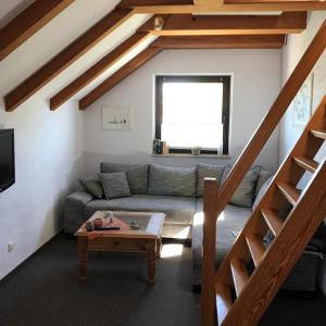 a living room with a couch and a table at Ferienwohnung Ostseeperle in Lemkenhafen auf Fehmarn