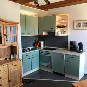 een keuken met blauwe kasten en een wastafel bij Ferienwohnung Ostseeperle in Lemkenhafen auf Fehmarn