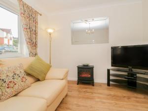 a living room with a couch and a flat screen tv at Bay View House in Colwyn Bay