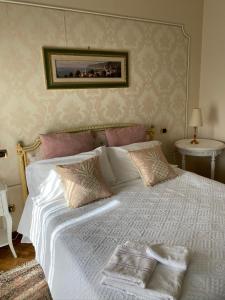 una camera da letto con un grande letto bianco con cuscini di I Citri a Taranto