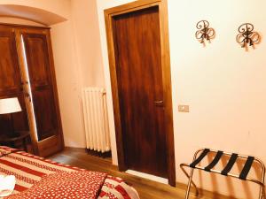 ドモドッソラにあるロカンダ ピエモンテ ダ ショッラのベッドルーム1室(ベッド1台付)、木製のドア