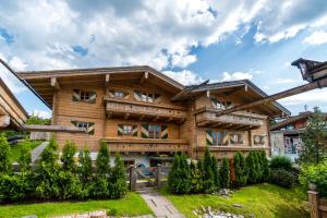 ein großes Holzhaus mit Hof in der Unterkunft Chalets Berglehen in Sankt Johann in Tirol