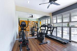 a gym with treadmills and ellipticals in a room at D Varee Xpress Fullroom 77 Srinakarin in Samutprakarn