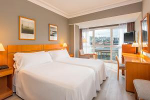 a hotel room with a large white bed and a window at Hotel San Sebastián Orly, Affiliated by Meliá in Donostia-San Sebastián