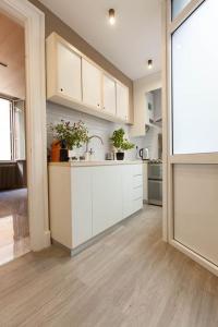 a kitchen with white cabinets and a sink at Casa Vacanze al Corso in Rome