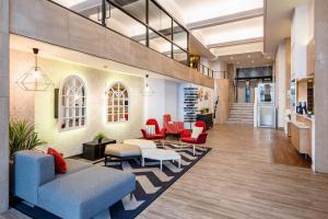 a lobby of a building with chairs and tables at Hotel San Sebastián Orly, Affiliated by Meliá in Donostia-San Sebastián