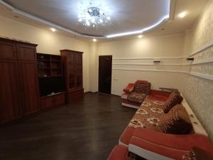 een woonkamer met een bed en een kroonluchter bij Квартира на Данилевского in Charkov