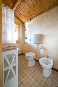 a bathroom with a toilet and a sink in it at Chalet Tenuta Lacco in Furnari