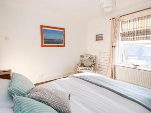 une chambre avec un lit, une chaise et une fenêtre dans l'établissement Carrstone Cottage, à Heacham