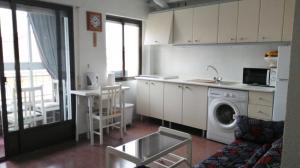 eine Küche mit einer Waschmaschine und einem Sofa in der Unterkunft Edificio Laura in San Pedro del Pinatar