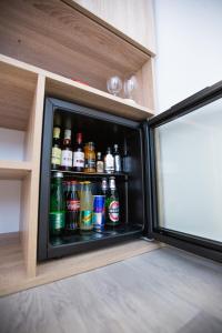 a refrigerator filled with lots of bottles of soda at Gloria Rooms in Požega