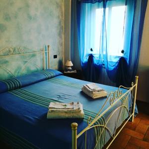 Schlafzimmer mit blauem Bett und blauen Vorhängen in der Unterkunft B&B SABRINA in Maratea