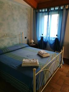 Schlafzimmer mit einem Bett mit blauer Bettwäsche und einem Fenster in der Unterkunft B&B SABRINA in Maratea