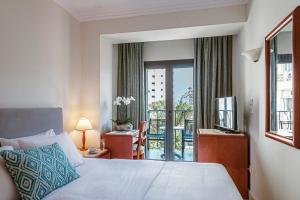a hotel room with a bed and a balcony at Mitsis La Vita in Rhodes Town