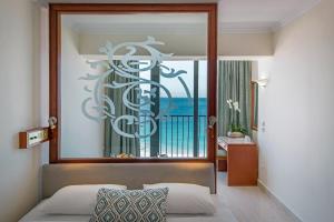 a bedroom with a bed with a mirror above it at Mitsis La Vita in Rhodes Town