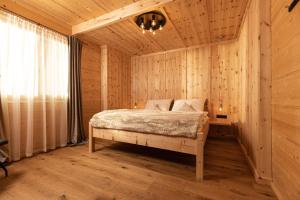 a bedroom with a bed in a wooden room at Naturlodge Tirol - Naturverbunden im Zillertal in Fügen
