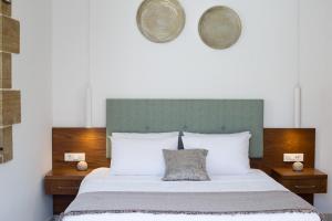 Agarathos Deluxe Homes في كيساموس: سرير مع وسائد بيضاء و اللوح الأمامي أخضر
