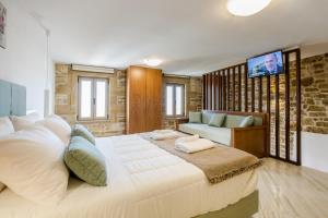 1 dormitorio con 1 cama blanca grande y 1 sofá en Agarathos Deluxe Homes, en Kissamos