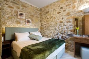 a bedroom with a bed and a stone wall at Agarathos Deluxe Homes in Kissamos