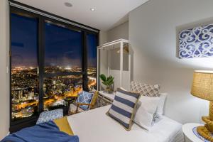 una stanza con tavolo e sedie e una grande finestra di Hamptons Retreat on Level 77 Skytower a Brisbane Altre 26 foto