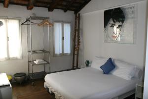 a bedroom with a white bed with a blue pillow at 19 Borgo Cavour in Treviso