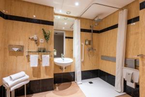 a bathroom with a sink and a shower at Hotel San Sebastián Orly, Affiliated by Meliá in Donostia-San Sebastián