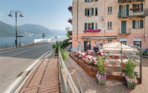 a building with tables and umbrellas next to a street at Light Blue Lake Aria in Argegno