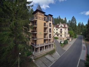 ein Gebäude mit einer Rolltreppe neben einer Straße in der Unterkunft Spa Apartments St. Moritz in Marienbad