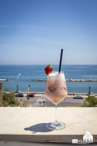 a drink sitting on a table with a strawberry in it at B&B La Muraglia in Bari