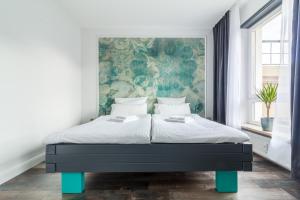um quarto com uma cama grande e uma pintura na parede em zentrales 130 qm Design-Appartement mit Extras em Karlsruhe mais 19 fotografias