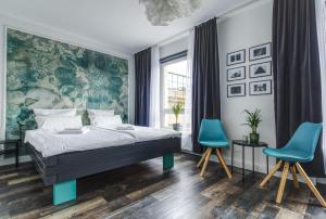 1 dormitorio con 1 cama y 2 sillas azules en zentrales 130 qm Design-Appartement mit Extras en Karlsruhe