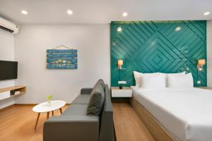 a bedroom with a bed and a couch and a tv at Dolphin Hotel and Apartment in Danang