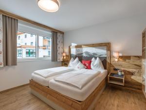 a bedroom with a large bed and a large window at Echt Woods Appartements in Söll