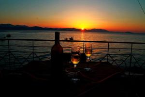 dois copos de vinho sentados numa mesa com o pôr-do-sol em Blue Sky Studios em Xiropigado