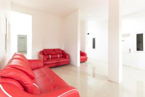 um sofá vermelho e duas cadeiras num quarto em Reddoorz @ Medan Johor em Medan