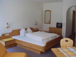 a bedroom with a large bed and a mirror at Haus Alpengruss in Sankt Leonhard im Pitztal