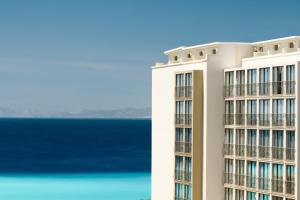 a tall building with the ocean in the background at Mitsis La Vita in Rhodes Town