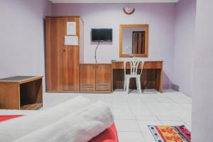 a bedroom with a desk with a television and a chair at Reddoorz near Nagoya Hill Mall Batam 5 in Batam Center