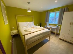 a bedroom with a bed with green walls at Aaron Wise - 17 Fitzhamon Apartments in Cardiff
